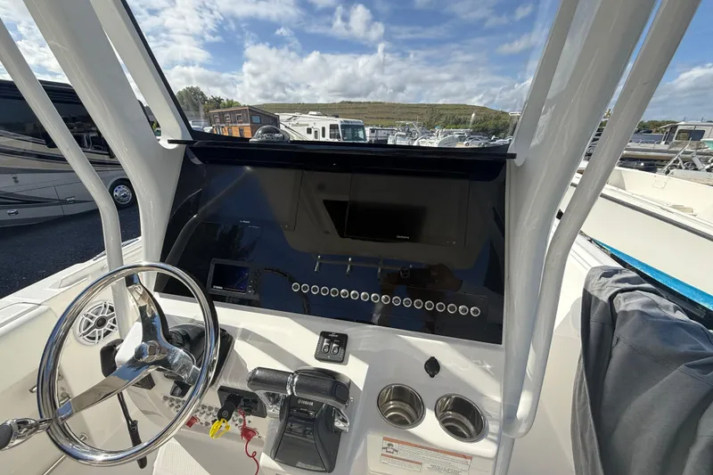 Slide: The Image of 2021 Edgewater 262CC boat dashboard with steering wheel and control panel. - 13