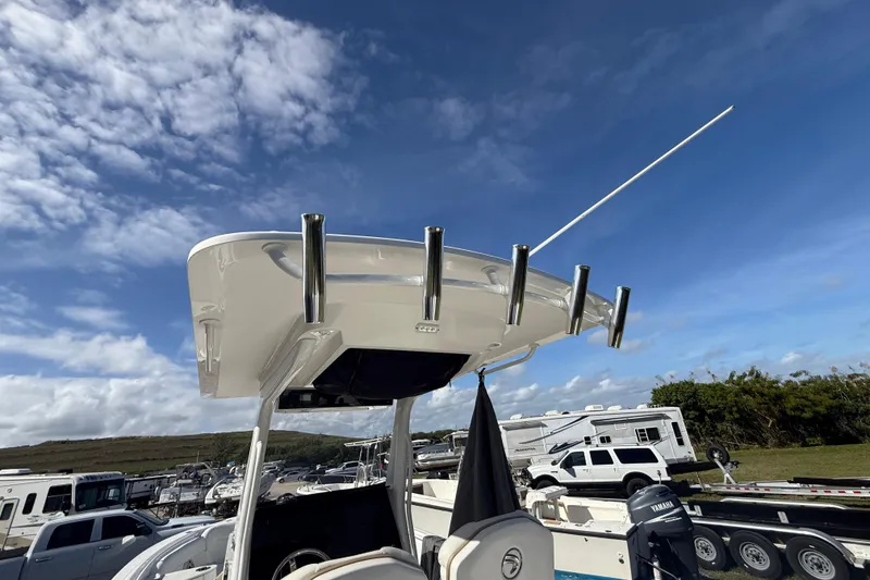 Slide: The Image of 2021 Edgewater 262CC boat with rod holders, parked under a clear blue sky. - 15