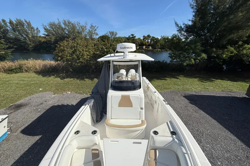 Slide: The Image of 2021 Edgewater 262CC boat with Garmin equipment, parked near a scenic river. - 17
