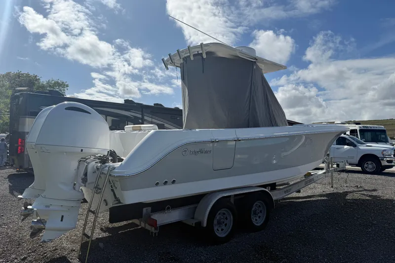 Slide: The Image of 2021 Edgewater 262CC boat on trailer under clear sky. - 3
