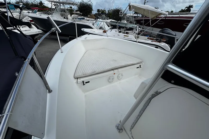 Slide: The Image of 2023 Hydra-Sports 212 CC boat interior with cushioned seating, docked among other boats. - 16