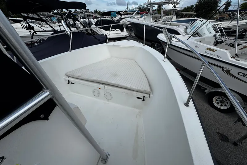 Slide: The Image of 2023 Hydra-Sports 212 CC boat interior with cushioned seating, surrounded by other boats. - 17