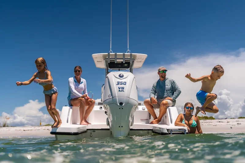 Slide: The Image of Family enjoying a day on the 2026 Edgewater 250CC boat at the beach. - 3