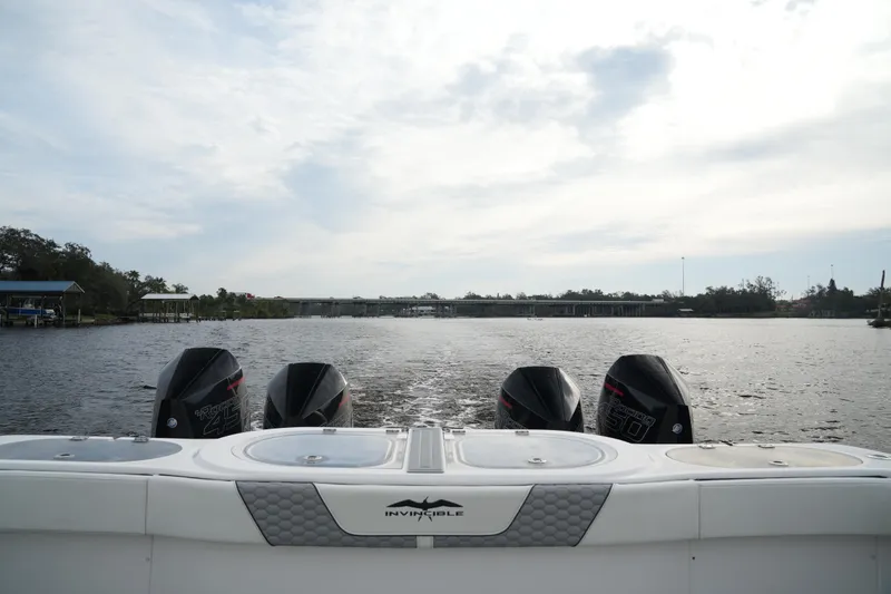 Slide: The Image of Invincible 46 Catamaran 2022 with four engines on a calm river. - 25