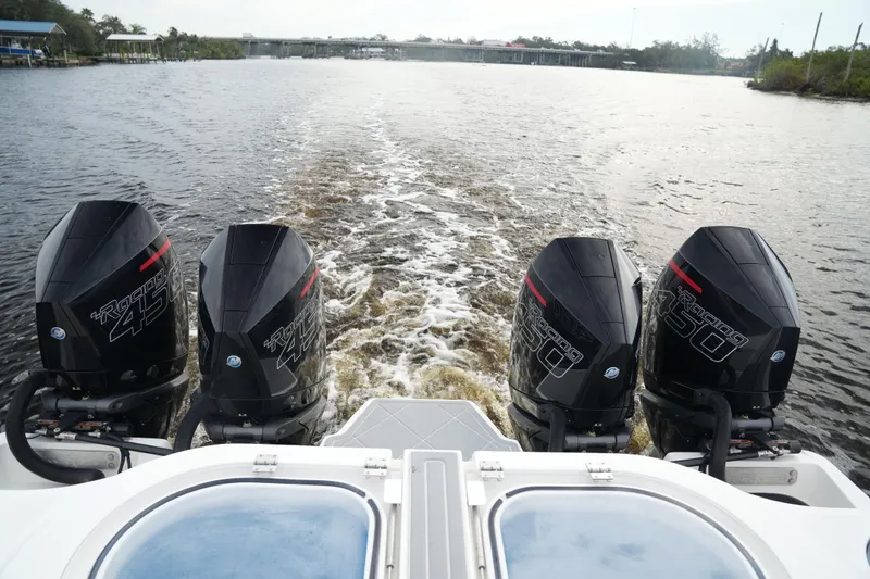 Slide: The Image of 2022 Invincible 46 Catamaran with quad outboard engines cruising on a river. - 27