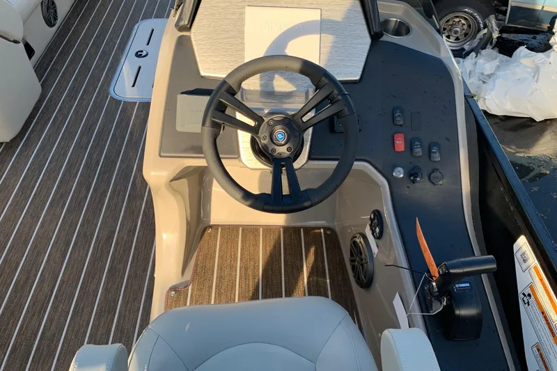 Slide: The Image of 2023 Premier 250 SunSation RF boat dashboard with steering wheel and controls. - 3