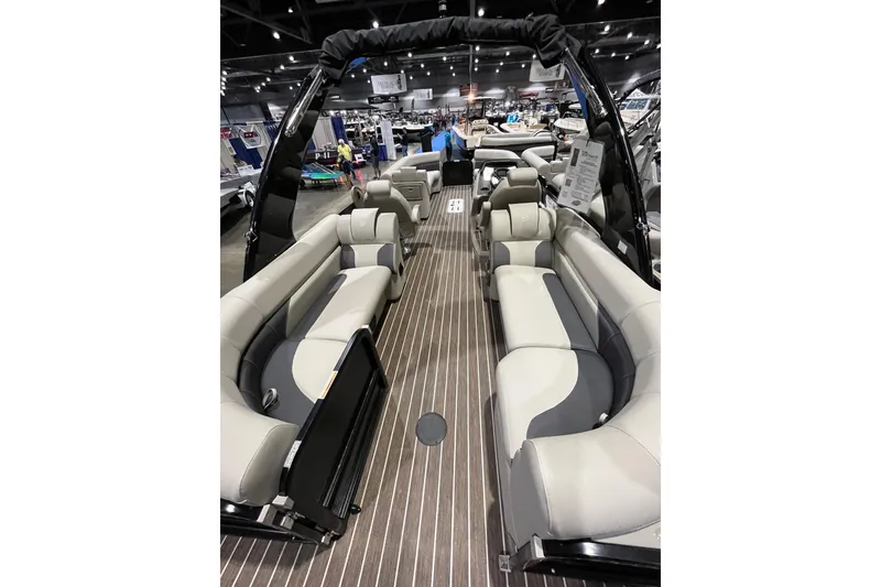 Slide: The Image of 2023 Premier 250 SunSation RF pontoon boat interior with luxurious seating at a boat show. - 6