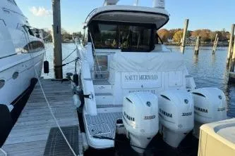 Slide: The Image of 2021 Regal 38 XO yacht docked in marina, sleek white design, modern features. - 10