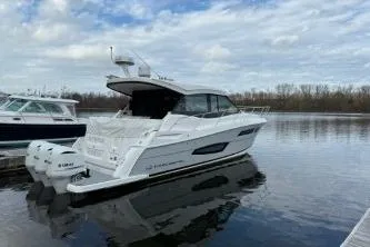 Slide: The Image of 2021 Regal 38 XO boat docked with triple outboard engines, calm water background. - 12