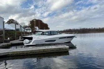 Slide: The Image of 2021 Regal 38 XO boat docked with triple outboard engines. - 15