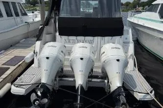 Slide: The Image of 2021 Regal 38 XO boat with triple Yamaha outboard engines docked. - 17