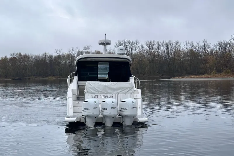 Slide: The Image of 2021 Regal 38 XO boat with triple Yamaha engines on a calm lake. - 3