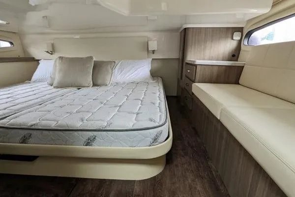 Slide: The Image of 2021 Regal 38 XO cabin interior with bed, sofa, and window view. - 38