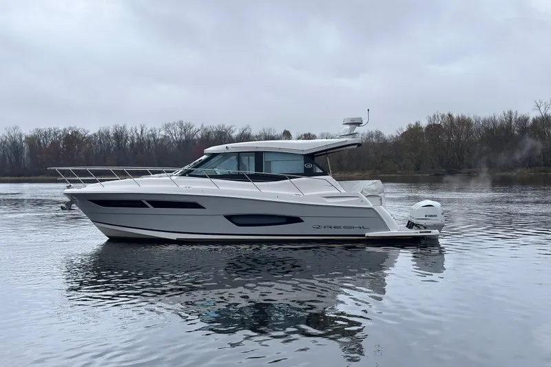 Slide: The Image of 2021 Regal 38 XO boat on calm water with overcast sky. - 5