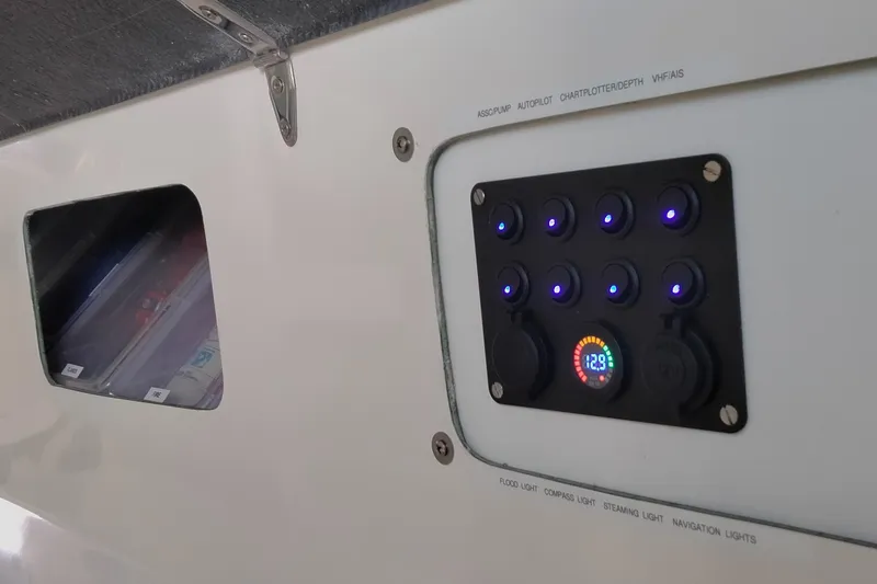 Slide: The Image of Control panel on a 2005 Corsair F-31 1D boat with illuminated switches and voltage display. - 13