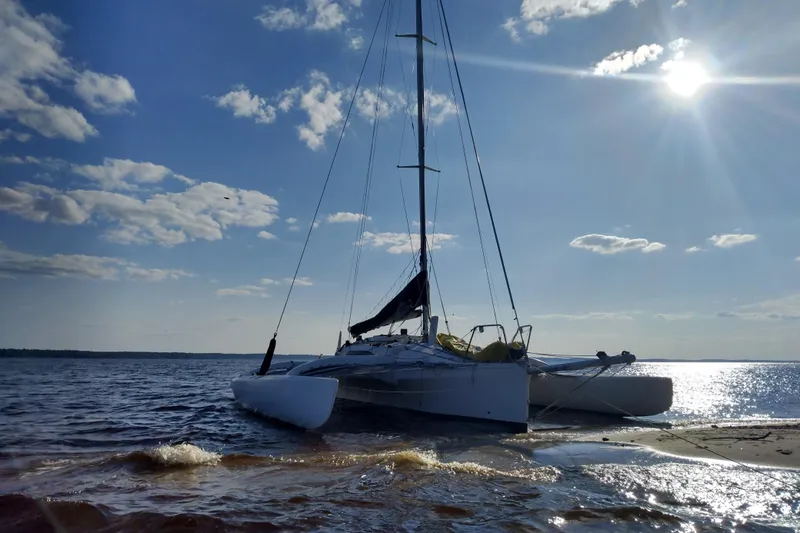 Slide: The Image of Sailboat Corsair F-31 1D, 2005 model, anchored on a sunny beach. - 4