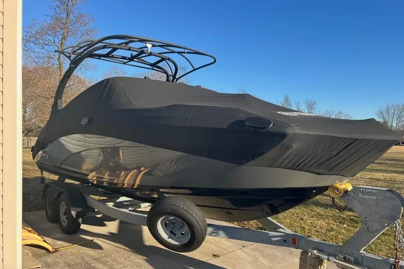Slide: The Image of 2019 Yamaha Boats 242 Limited S E-Series docked at marina, sleek design, black canopy. - 3