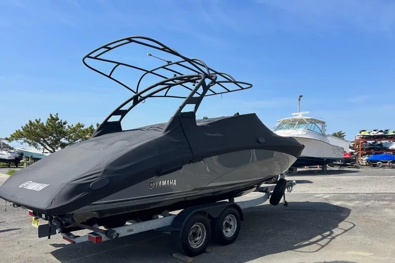 Slide: The Image of 2019 Yamaha Boats 242 Limited S E-Series on trailer, parked beside another boat. - 4