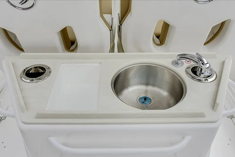 Slide: The Image of 2026 Edgewater 262CC boat sink with faucet and cup holder on white countertop. - 8