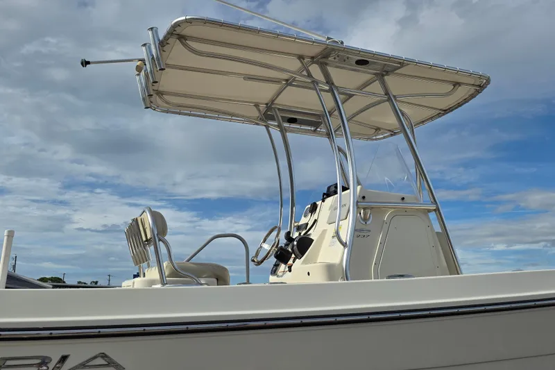 Slide: The Image of 2021 Cobia 237 Center Console boat with T-top against a cloudy sky. - 19