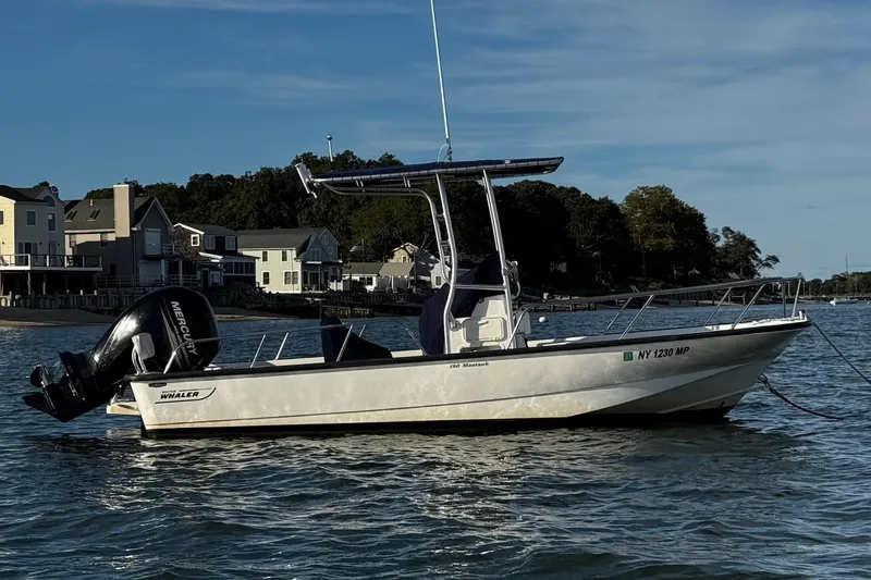 The Image of 2018 Boston Whaler 190 Montauk boat on water near shoreline houses. - 0