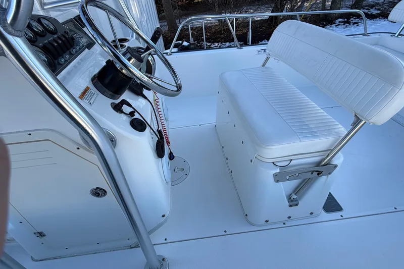Slide: The Image of 2018 Boston Whaler 190 Montauk boat on open water, featuring steering console and canopy. - 15