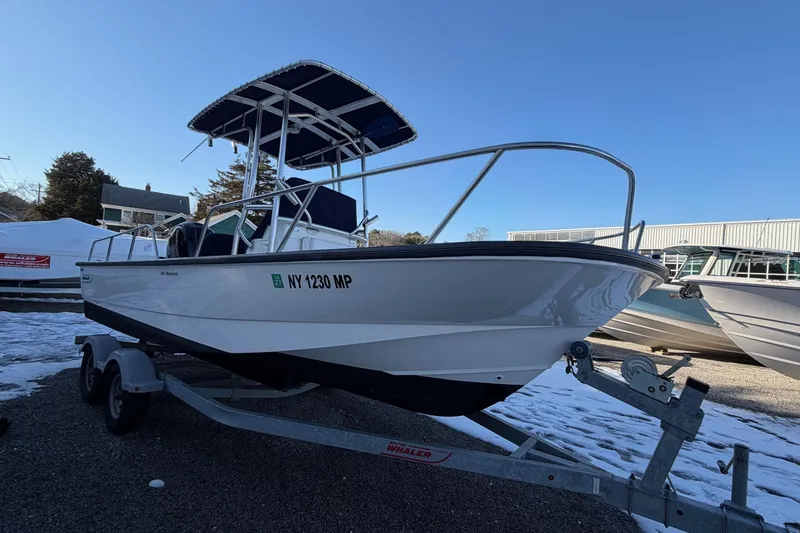 Slide: The Image of 2018 Boston Whaler 190 Montauk boat docked near waterfront homes. - 37