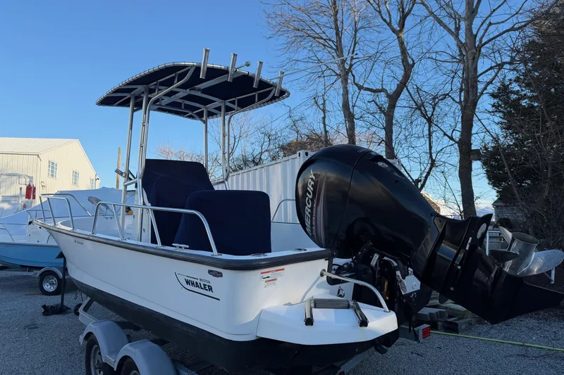 Slide: The Image of 2018 Boston Whaler 190 Montauk boat with Mercury engine, parked outdoors. - 42