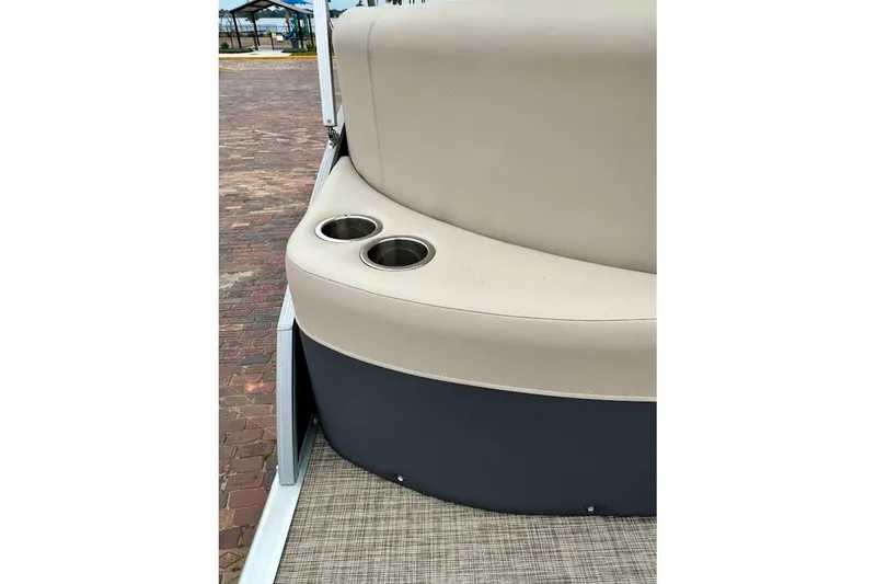 Slide: The Image of 2023 Harris Cruiser 230 boat seat with cup holders on a brick-paved dock. - 14