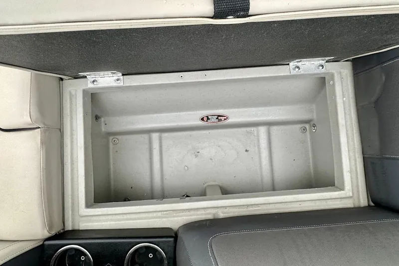 Slide: The Image of 2023 Harris Cruiser 230 storage compartment with cup holders and cushioned seating. - 18
