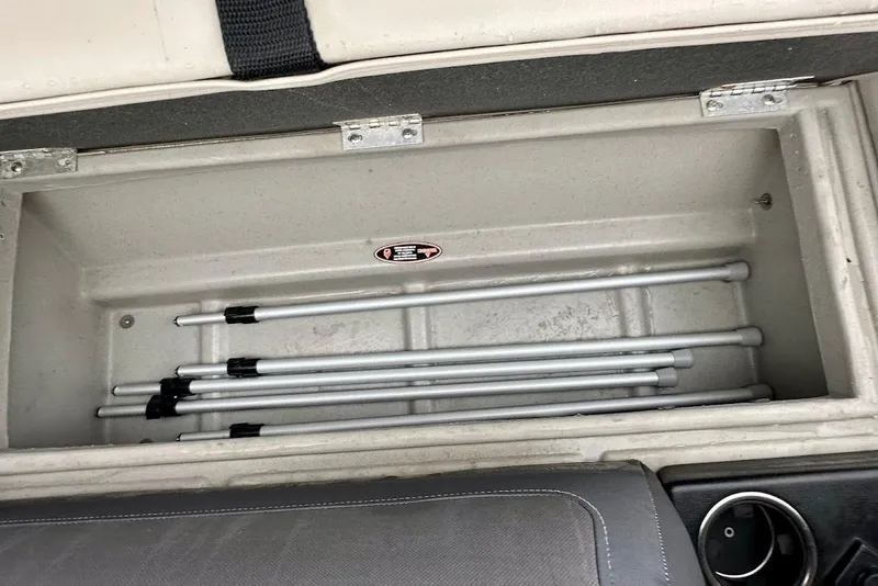 Slide: The Image of Storage compartment in a 2023 Harris Cruiser 230 boat with metal poles inside. - 20