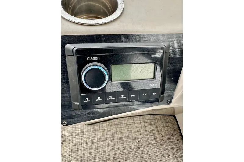 Slide: The Image of 2023 Harris Cruiser 230 dashboard with Clarion audio system and cup holder. - 27