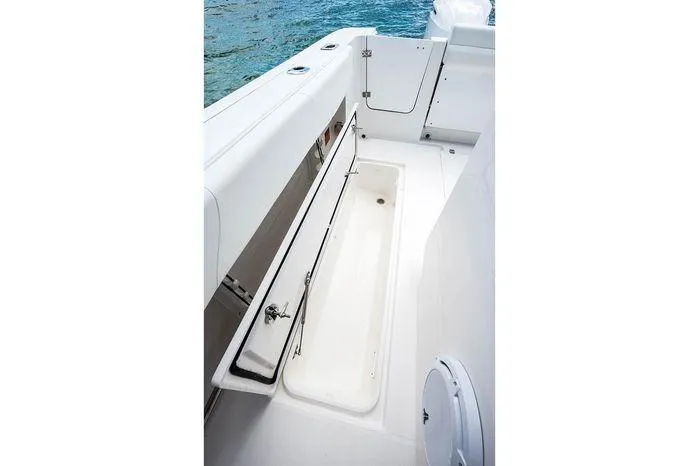 Slide: The Image of 2026 Edgewater 285CC boat deck with open storage compartment by the water. - 10