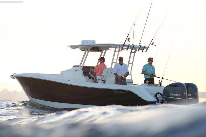 Slide: The Image of 2026 Edgewater 285CC boat with three people fishing at sunrise on the ocean. - 2
