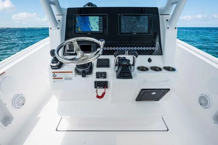 Slide: The Image of 2026 Edgewater 285CC boat dashboard with dual screens and steering wheel on open water. - 6