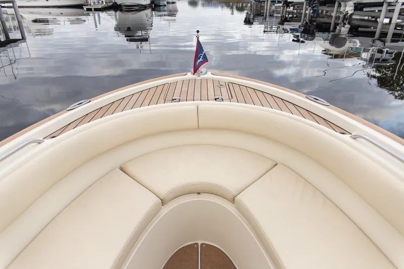 Slide: The Image of 2016 Chris-Craft Catalina 26 boat with elegant seating and wooden deck, docked on calm water. - 10