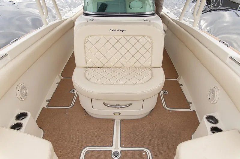 Slide: The Image of 2016 Chris-Craft Catalina 26 interior with beige seating and carpeted flooring. - 11