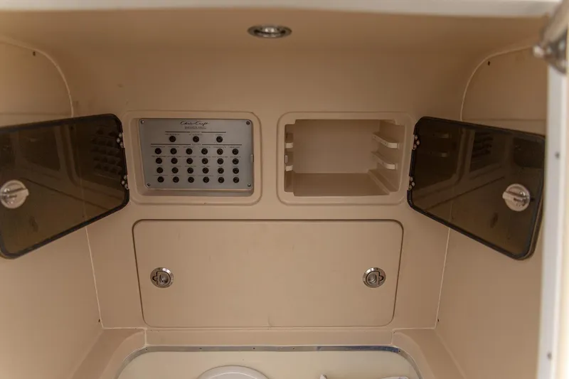 Slide: The Image of 2016 Chris-Craft Catalina 26 interior storage compartments and control panel. - 14