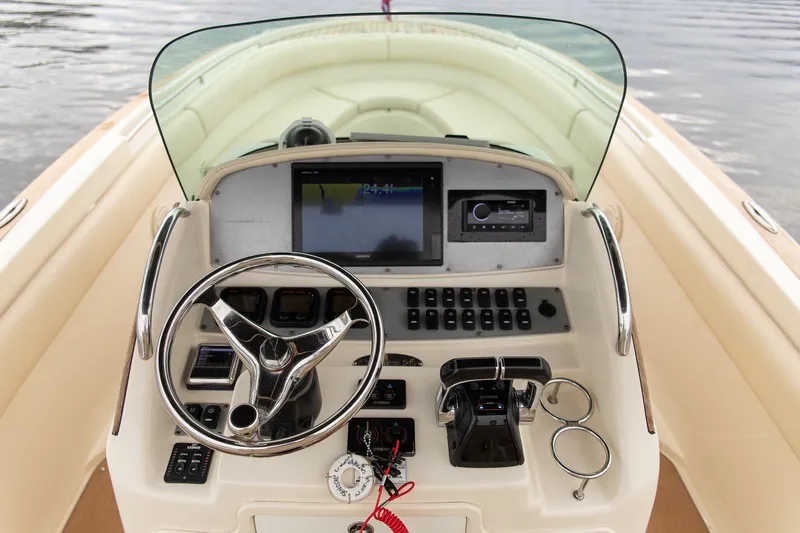Slide: The Image of 2016 Chris-Craft Catalina 26 helm with steering wheel, controls, and navigation display. - 17