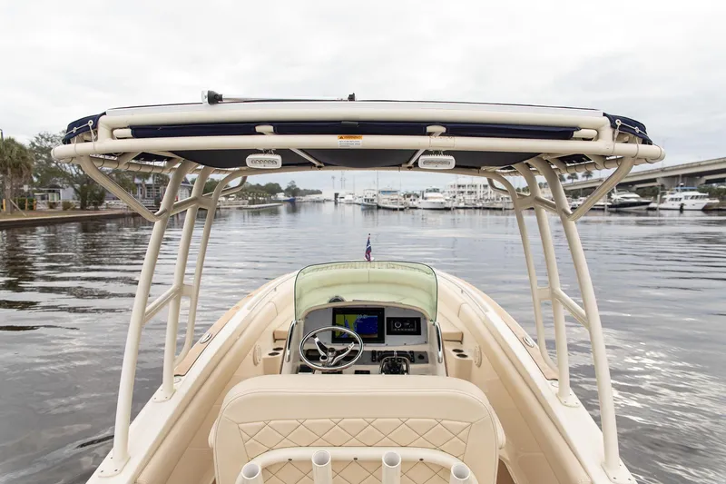Slide: The Image of 2016 Chris-Craft Catalina 26 boat on calm water, featuring a sleek helm and T-top. - 19