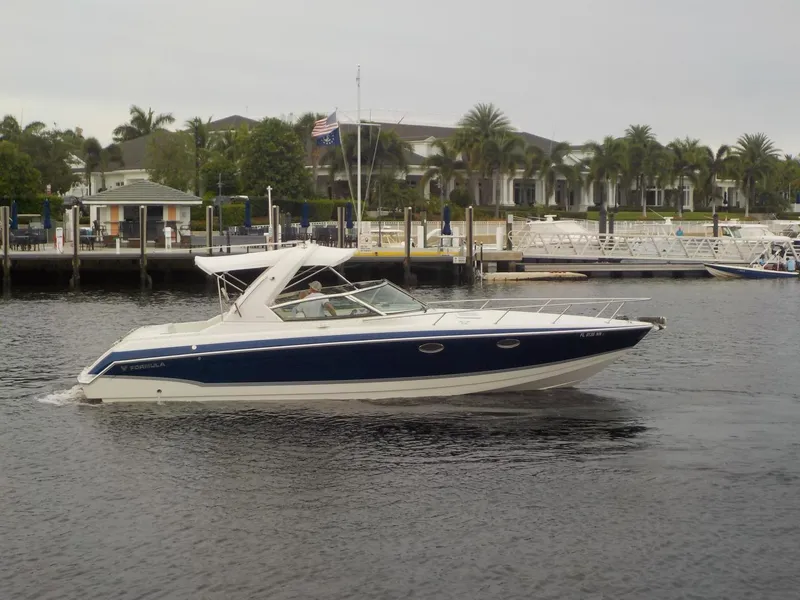 The Image of 2006 Formula 330 SS boat cruising on a calm waterfront near a marina. - 0