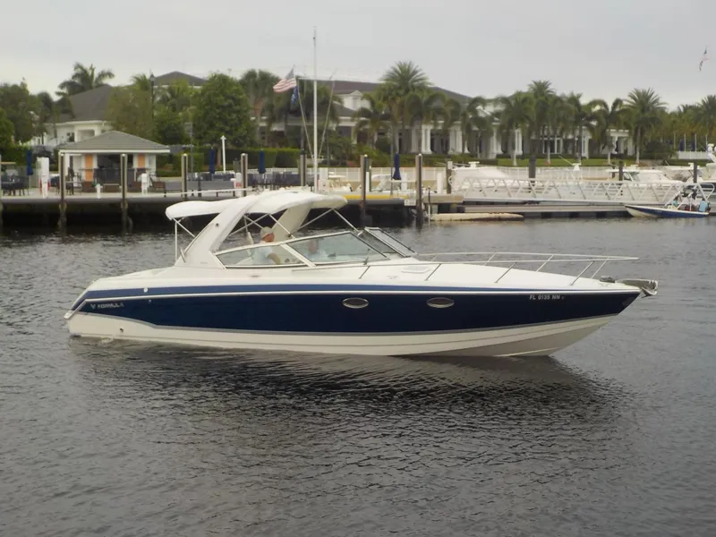 Slide: The Image of 2006 Formula 330 SS boat on calm water near a marina. - 2