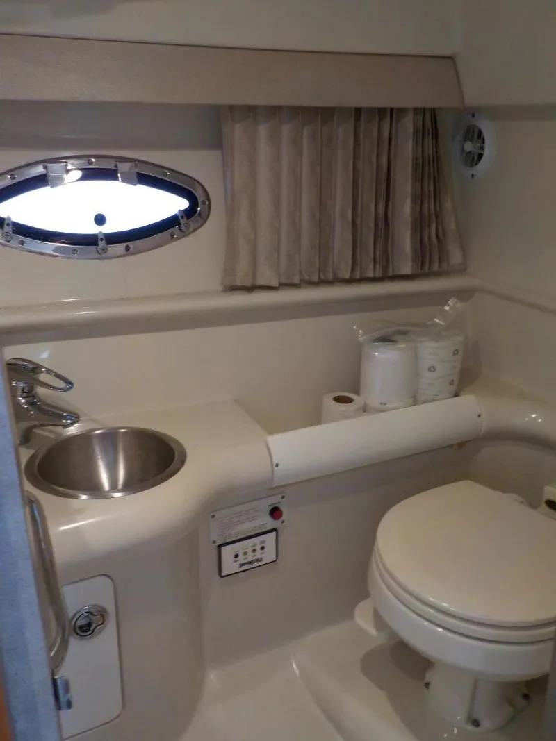 Slide: The Image of 2006 Formula 330 SS boat bathroom with sink, toilet, and porthole window. - 4