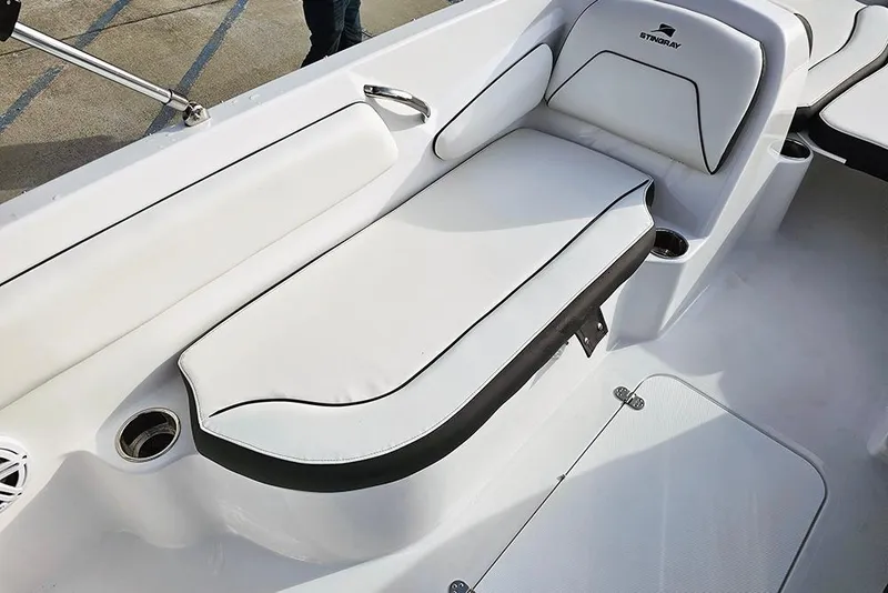 Slide: The Image of 2026 Stingray 182 SC boat interior with white cushioned seating and cup holders. - 16
