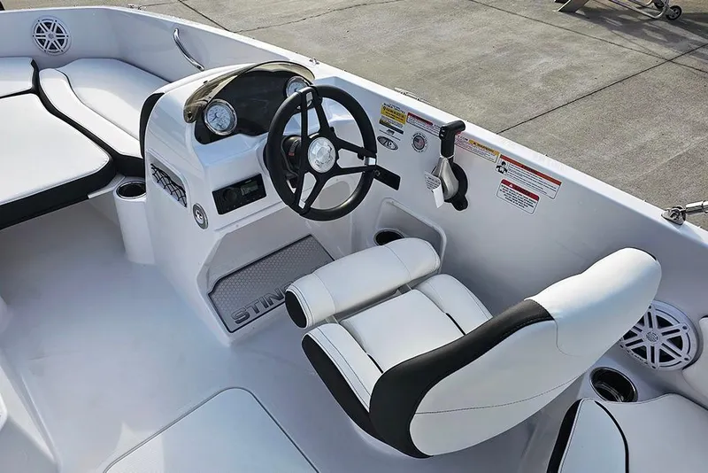 Slide: The Image of 2026 Stingray 182 SC boat interior with steering wheel and white seating. - 18