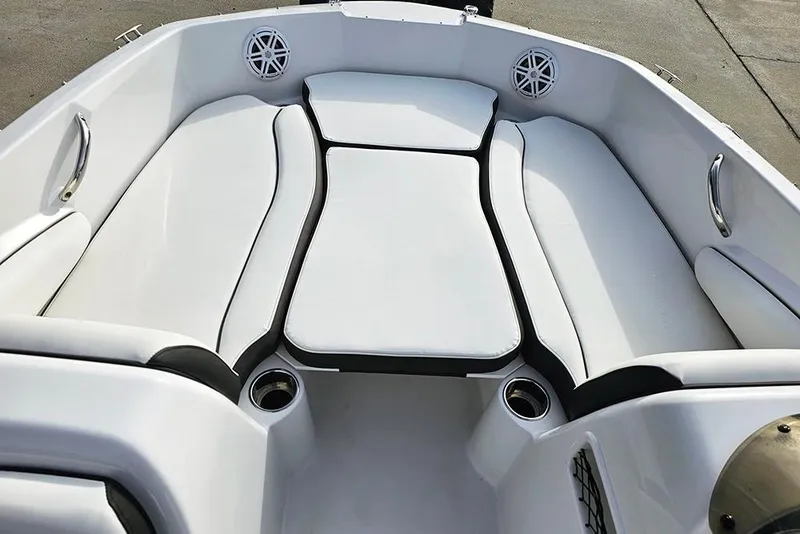 Slide: The Image of 2026 Stingray 182 SC boat interior with white cushioned seating and cup holders. - 22