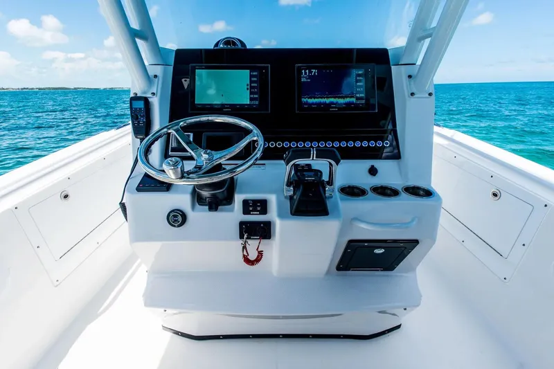 Slide: The Image of 2026 Edgewater 325CC boat helm with modern navigation system on open sea. - 13