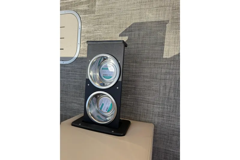 Slide: The Image of Dual cup holders on Bentley Pontoons Elite 253 Admiral, 2026 model, with textured wall background. - 11