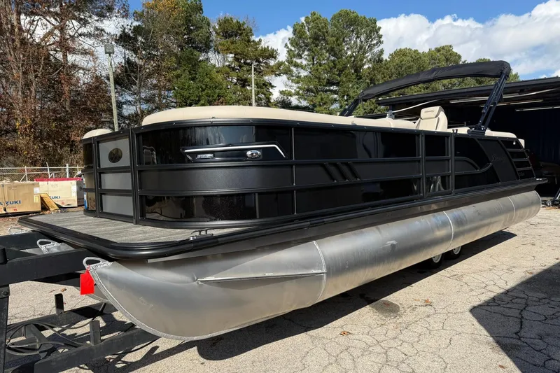 Slide: The Image of 2026 Bentley Pontoons Elite 253 Admiral pontoon boat on trailer, surrounded by trees. - 3