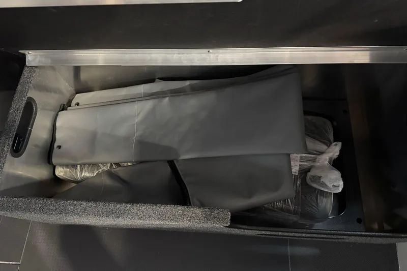 Slide: The Image of Storage compartment in 2026 Duckworth 23 Pacific Navigator boat, containing folded gray covers. - 21